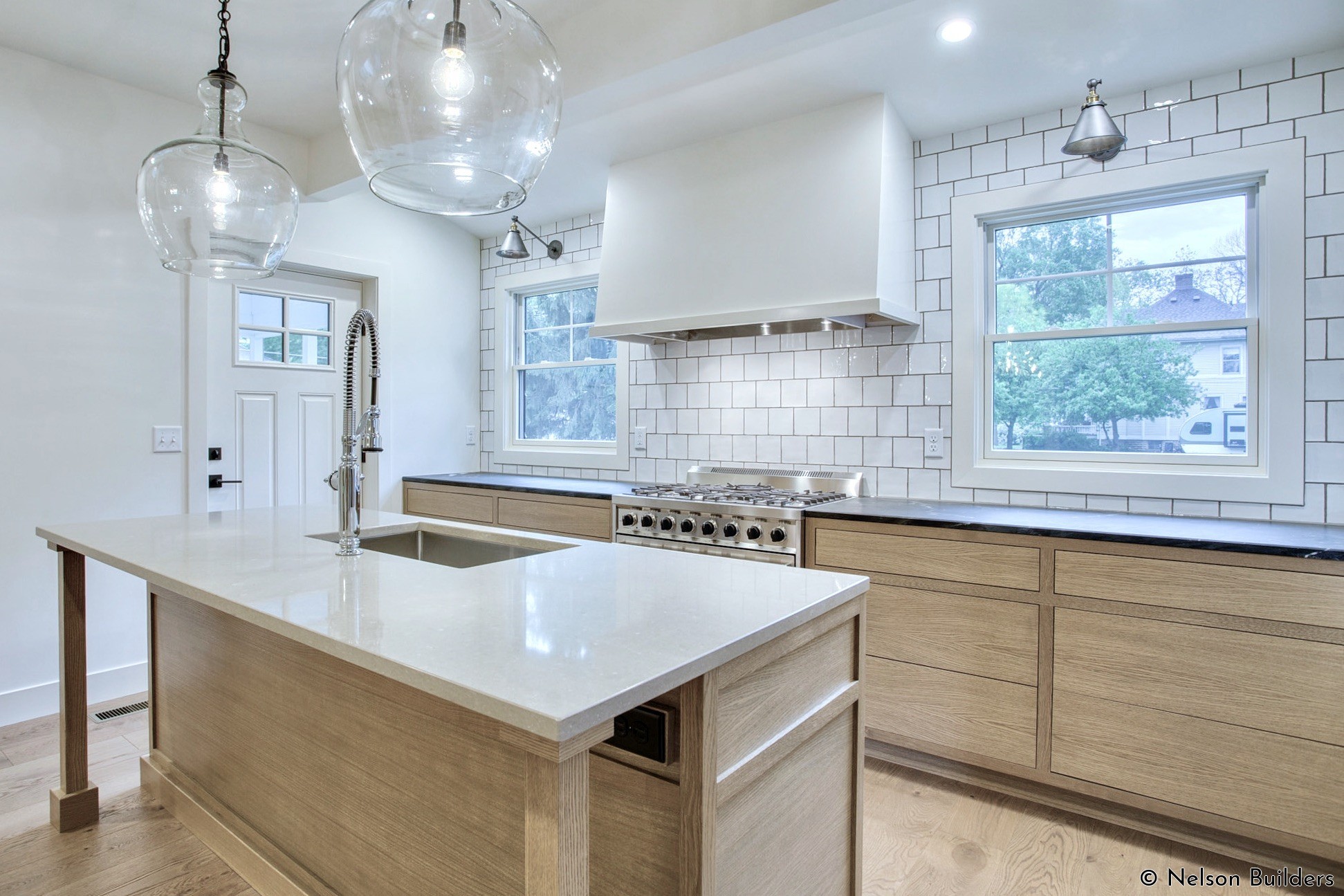 The white oak cabinets and built-in hood were custom made by the client's father, a personal touch for a family home.