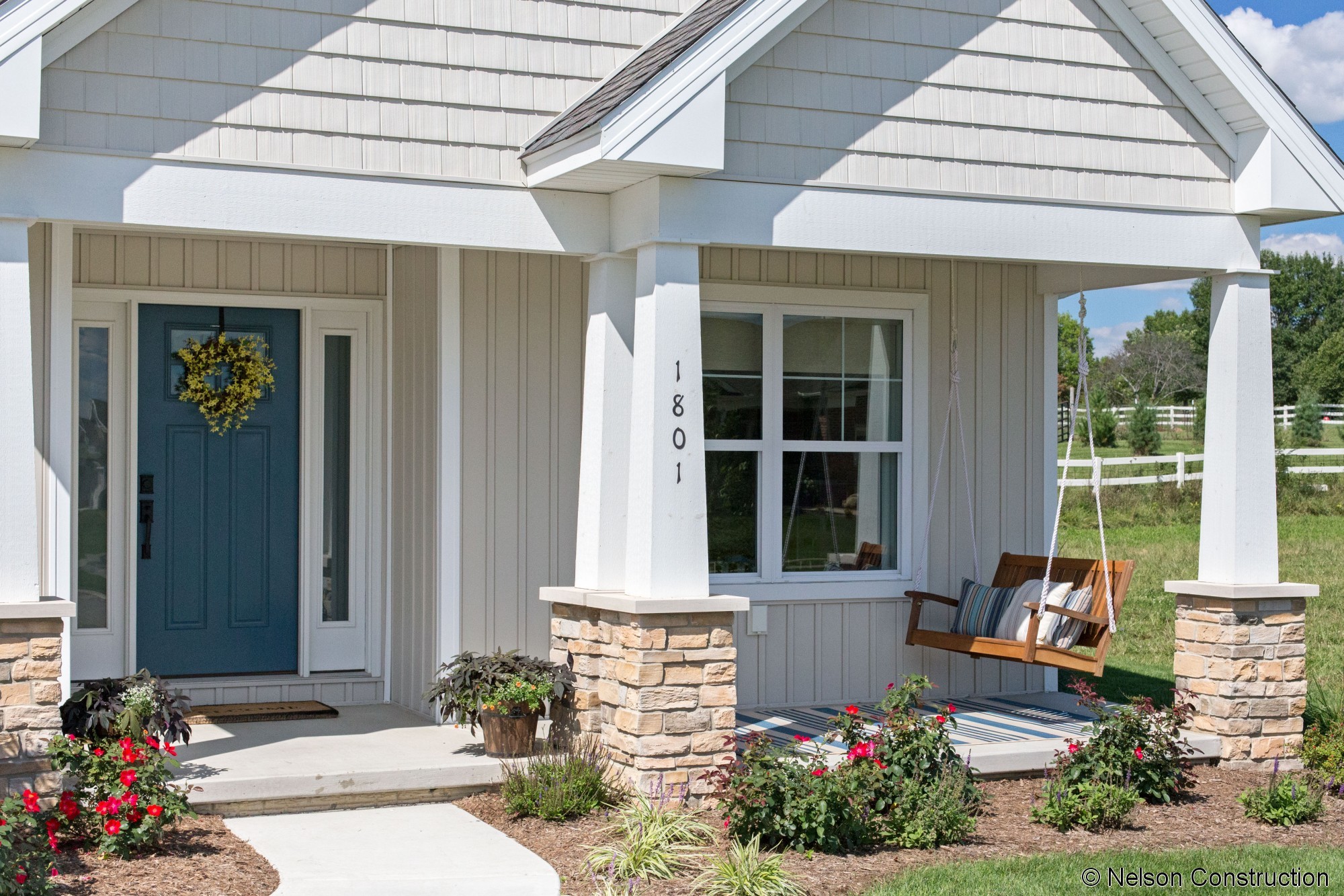 The front porch of this Sycamore home is warm and inviting with a porch swing to complete the space.