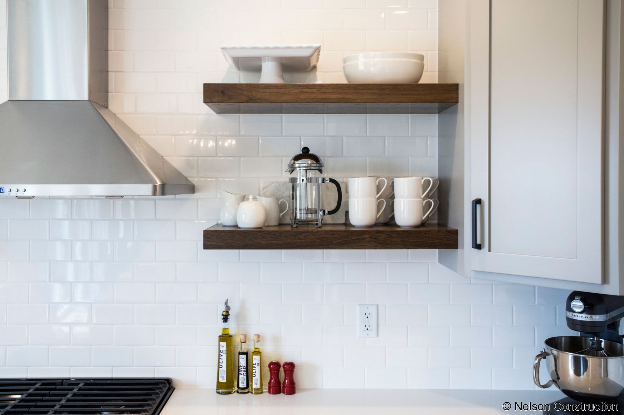 The kitchen of this new home by Nelson Builders is highlighted by the rustic hickory island and floating shelves.